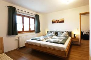 a bedroom with a bed and a window at Paulhuberhof in Chieming