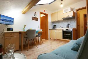 a kitchen and living room with a couch and a table at Paulhuberhof in Chieming