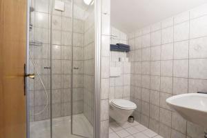 a bathroom with a shower and a toilet and a sink at Paulhuberhof in Chieming