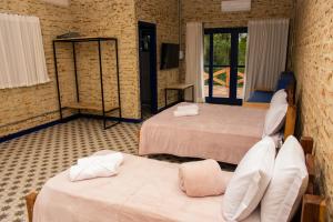 a hotel room with two beds and a tv at Fazenda Castanheira in Monte Verde +14 photos