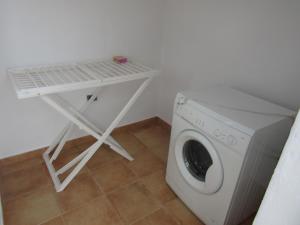 a small white table next to a washing machine at La Casita Villalba in Arrieta