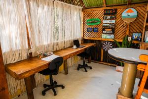 a room with a desk and two chairs and a laptop at Hotel PlayaScondida Baru in Barú