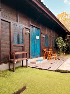 a house with a deck with two chairs and a table at The Tipsy Gypsy Hostel in Canggu