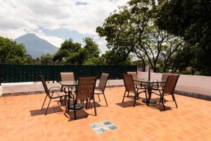 a table and chairs on a patio with a mountain at Los Faroles Hotel & Spa in Antigua Guatemala