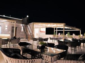 a group of tables and chairs in a patio at night at Tuya pyramids INN in Cairo