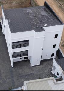 a white building with solar panels on the roof at Aulein Apartments in Abuja