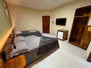 a hotel room with two beds and a television at Hotel Catavento in Cristalina