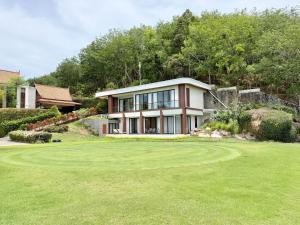 a house on top of a lush green yard at Royal Legacy Golf Private Villa in Rawai Beach