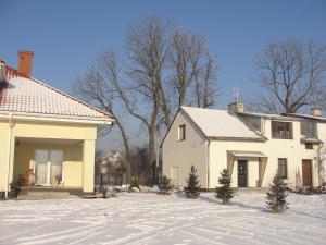 Biały dom ze śniegiem na ziemi w obiekcie Na Skarpie w mieście Wyszków