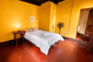 a bedroom with a white bed in a yellow wall at Hotel Itzel in Cobán