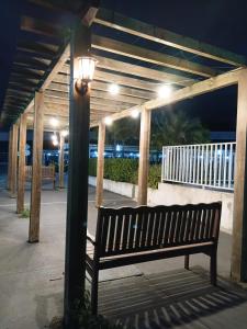 a park bench under a pergola at night at Apto aconchegante próximo à UFS in São Cristóvão +6 photos