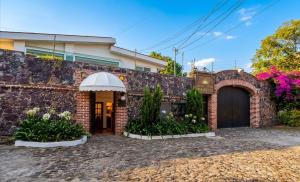 a brick house with a gate and a driveway at Nuevo Amanecer in Tepoztlán +4 photos