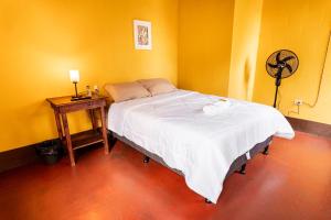 a bedroom with a bed and a table with a fan at Hotel Itzel in Cobán