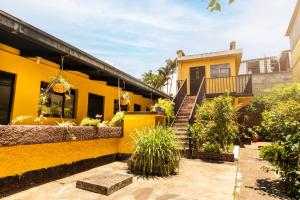 a yellow house with a staircase in front of it at Hotel Itzel in Cobán