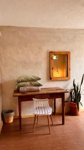a wooden table with a chair and a mirror at CASA LOOL BEH in San Miguel de Allende