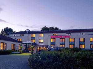 ein großes weißes Gebäude mit einem Schild darauf in der Unterkunft Mercure Tagungs- & Landhotel Krefeld in Krefeld