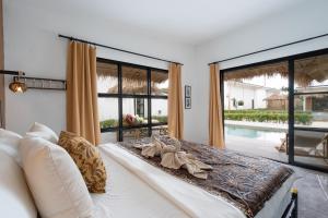 a bedroom with a bed and a large window at Manao Pool Villa 6 - 5 Mins Walk To The Beach in Ko Lanta