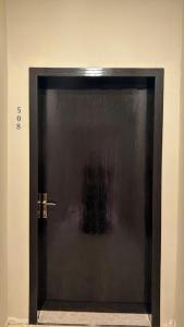 a black door in the corner of a room at شقة مفروشة أنيقة وهادئه in Al Ahsa
