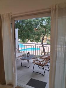 a balcony with a table and chairs and a pool at Vila Verde Sal Calistemon in Prainha