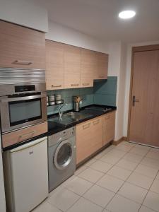 a kitchen with a washing machine and a washer at Vila Verde Sal Calistemon in Prainha