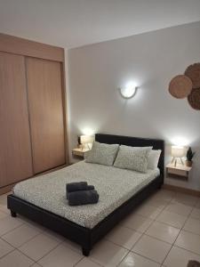 a bedroom with a bed with a black frame and pillows at Vila Verde Sal Calistemon in Prainha +24 photos