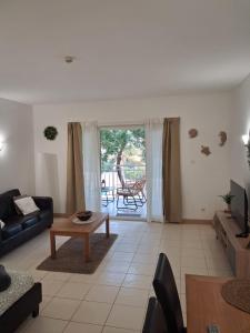 a living room with a couch and a table at Vila Verde Sal Calistemon in Prainha