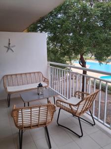 a balcony with two chairs and a table and a table at Vila Verde Sal Calistemon in Prainha