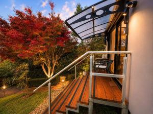 a wooden deck with a bench and an umbrella at Cosy Studio- Blue Mountains in Wentworth Falls +9 photos