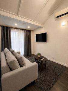 a living room with a couch and a flat screen tv at Cosy Studio- Blue Mountains in Wentworth Falls