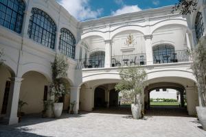 a large white building with a courtyard with trees at Hotel Casa Huamantla in Huamantla