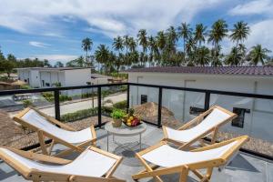 a patio with three chairs and a table on a balcony at Manao Pool Villa 9 - 5 Mins Walk To The Beach in Ko Lanta