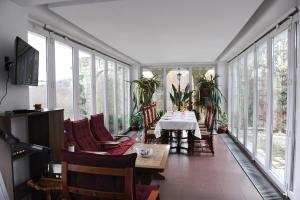 a dining room with a table and chairs and windows at Rapsodia Pension in Suceava