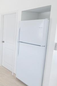 a white refrigerator in a kitchen next to a door at Swan cottages #6 Waterfront in Providenciales