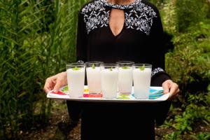 a woman holding a tray of glasses of milk at Hotel Pijibá Lodge in Nuquí