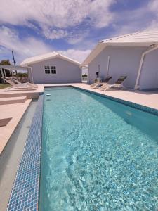 a swimming pool in front of a house at Swan cottages #6 Waterfront in Providenciales