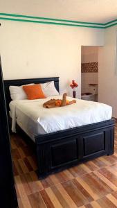 ein Bett mit einem Teddybären darauf in der Unterkunft Mozard Hotel in Cayes Jacmel
