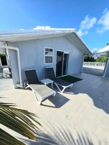 a patio with two chairs and a house at Swan Cottages #5 Waterfront in Providenciales