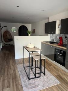 a living room with a table and a kitchen at Le Petit Cocon in Amiens