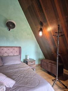 a bedroom with a bed and a lamp in a room at Orchid Chalet in Ringlet