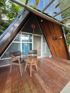 a room with a table and two chairs on a roof at Orchid Chalet in Ringlet