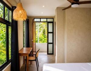 a bedroom with a table and a bed and a window at Hideout Siargao in General Luna