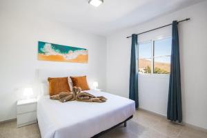 a bedroom with a white bed with a window at Apartamento Atenea in San Bartolomé
