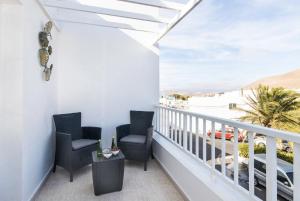 a balcony with chairs and a view of the beach at Apartamento Atenea in San Bartolomé