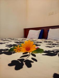 a bed with three flowers on it at SEE CHAIN Resort in Digana