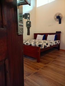 a small bed in a room with a cross on the wall at SEE CHAIN Resort in Digana
