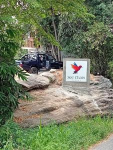 a sign sitting on top of a rock next to a car at SEE CHAIN Resort in Digana