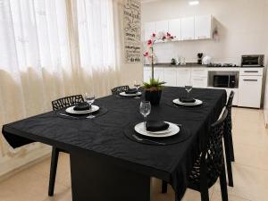 a dining room table with chairs and a black table cloth at Flat 2 quartos em residencial | Ar e garagem in Ourinhos