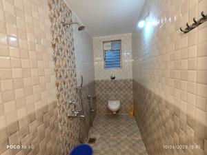 a bathroom with a shower and a toilet in it at Rajdeep by Dacha Arambol in Arambol