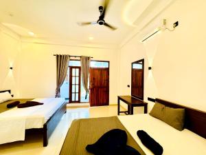 a bedroom with two beds and a ceiling fan at Surf del mar in Arugam Bay