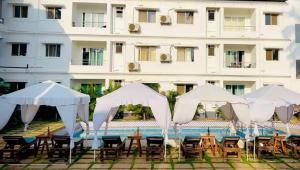 a group of tables and chairs next to a building at Rajdeep by Dacha Arambol in Arambol